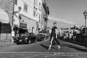 Sara Innocenti inflorencer attraversa la strada con Ponte Vecchio sullo sfondo