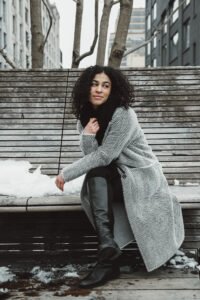 Donna seduta su panchina nella neve, ritratto candido invernale, New York City